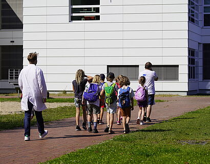 Kindergruppe mit den Betreuern auf dem Weg zum Biolabor