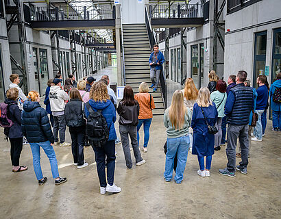 HIT 2025 Besucher*innen stehen bei einer Campustour der TH Wildau im Kreis und lauschen dem Vortragenden