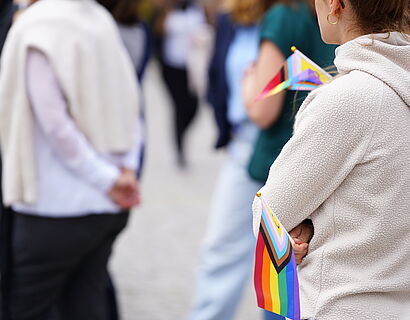 Diversity Day Rücken von zwei Menschen und eine kleine Regenbogenfahne