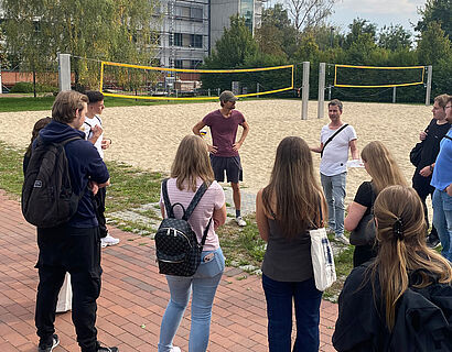 Studierende bei einer Campusführung an den Beachvolleyballfeldern der TH Wildau