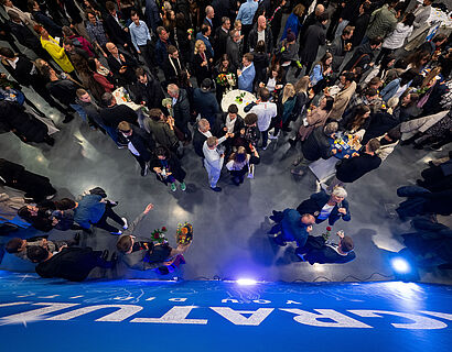 Blick von oben auf das mit vielen Personen gefüllte Foyer von Halle 17 bei der feierlichen Verabschiedung 2024