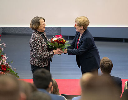 TH-Wildau-Präsidentin Prof. Ulrike Tippe übergibt einen Blumenstrauß an Prof. Burghilde Wieneke-Toutaoui bei der feierlichen Verabschiedung