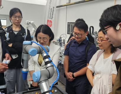 Gruppe von Menschen schaut in einem Labor auf einen Roboter