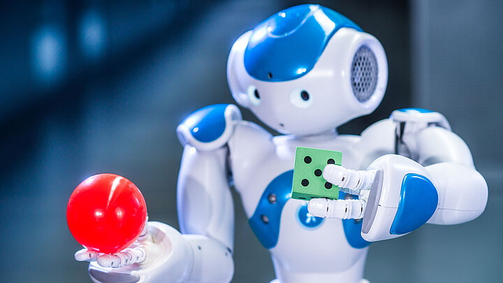 kleiner, süßer Roboter hantiert mit Ball