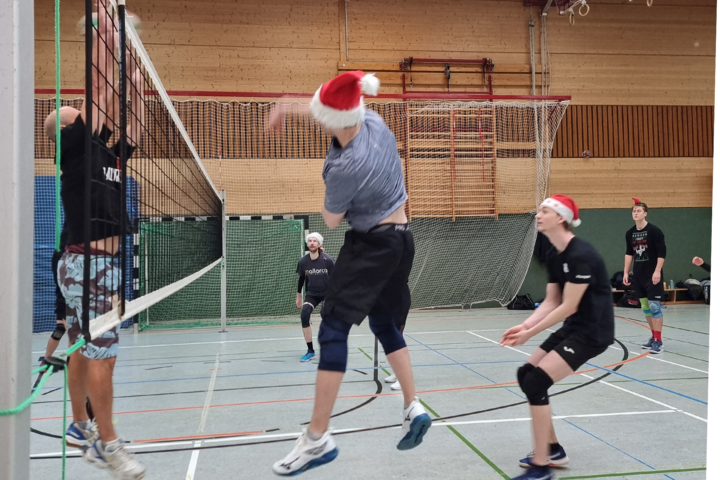 Junge Menschen beim Volleyballspiel in einer Turnhalle