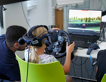 Kinder mit einer VR-Brille vor einem Bildschirm