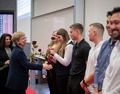 TH-Wildau-Präsidentin Prof. Ulrike Tippe gratuliert einer Absolventin und übergibt ihr eine Rose bei der feierlichen Verabschiedung 2024