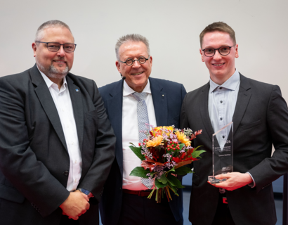 drei Männer in Anzügen lächeln in die Kamera