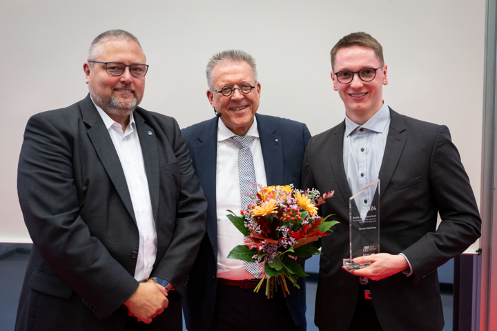 drei Männer in Anzügen lächeln in die Kamera