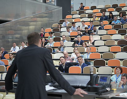 Prof. Stefan Kubica spricht vor Publikum im großen Hörsaal von Halle 14 beim Verwaltungstag