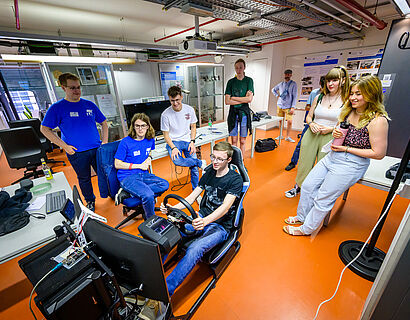 Besucherinnen und Besucher im Labor beim Fahrsimulator der TH Wildau.
