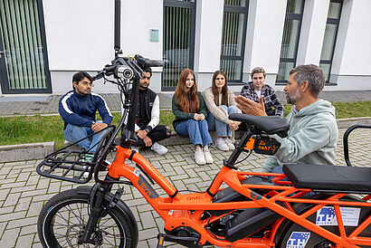 Christian Rudolph mit Studierenden draußen mit einem Lastenrad