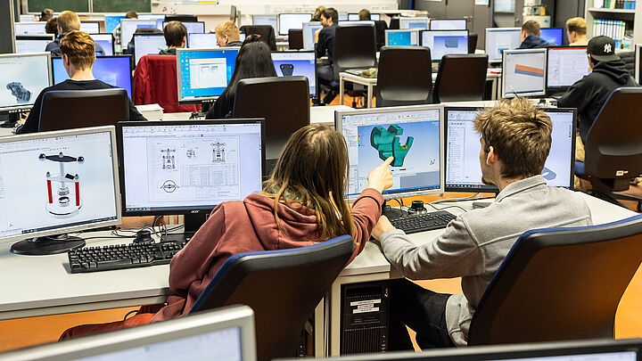 Studierende bei der Vorlesung vor PCs mit Simulationen auf dem Bildschirm 