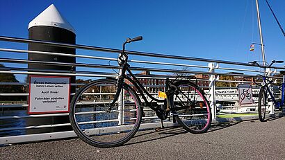 Ein Fahrrad an einem Geländer abgestellt